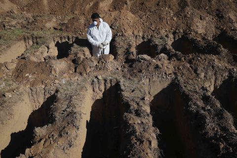 A cemetery worker pauses while digging graves at the San Vicente cemetery in Cordoba, Argentina.