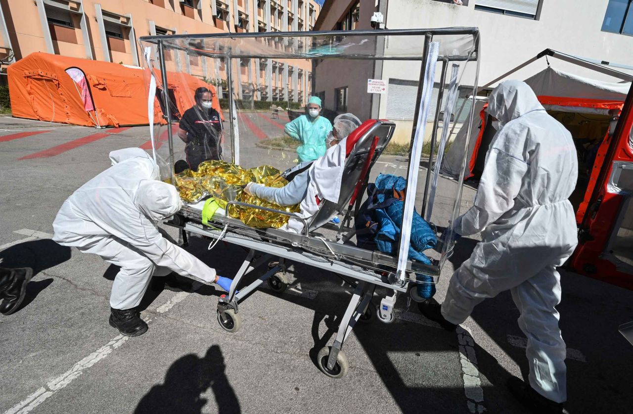 Firefighters transfer a patient from an ambulance in Montpelier, France, on April 14, 2020.