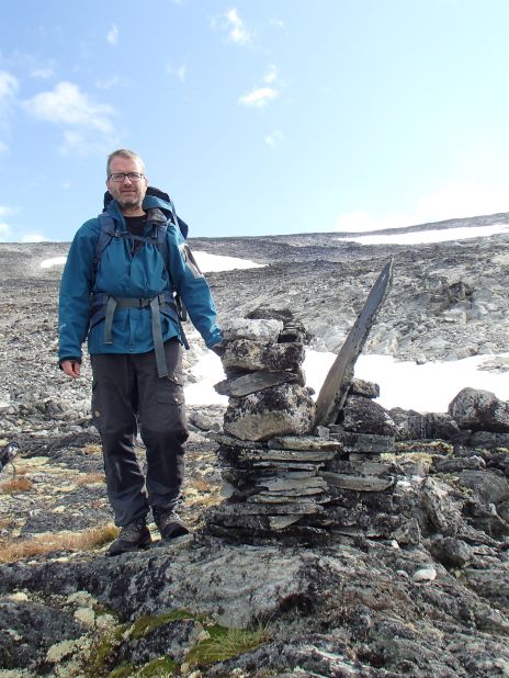 Researcher Lars Pilø is pictured by a cairn, which was used to mark the route of the mountain pass. 