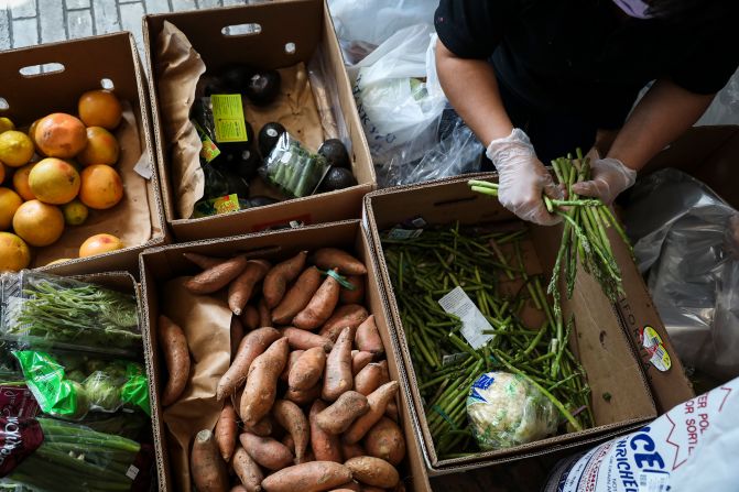 Gladys Socop helps to bag up food while volunteering at a pop-up food pantry in Chelsea, Massachusetts.