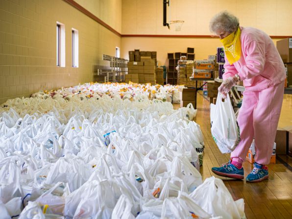 Volunteer Maria Cunningham sorts through bags of food before distributing them at a church in Des Moines, Iowa, in April.