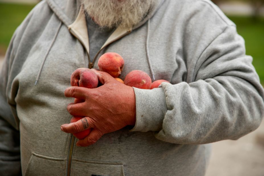 A volunteer holds fruit while helping to distribute food at Pantry 279 in Ellettsville, Indiana.