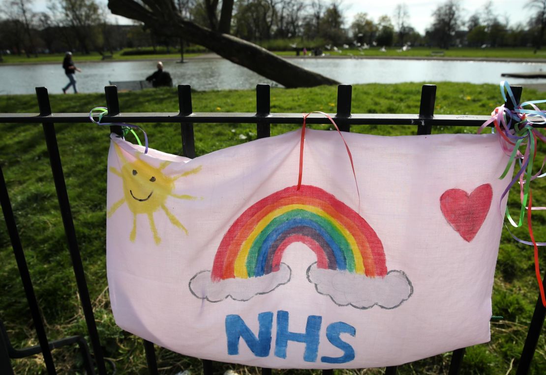 NHS tributes are painted on pillow cases attached to a fence at Elder Park in Glasgow.