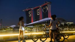 People look on as the letters and symbol SG Love, lights the facade of Marina Bay Sands as message of hope amid the nations fight against COVID-19 coronavirus in Singapore on April 10 , 2020. (Photo by Roslan RAHMAN / AFP) (Photo by ROSLAN RAHMAN/AFP via Getty Images)