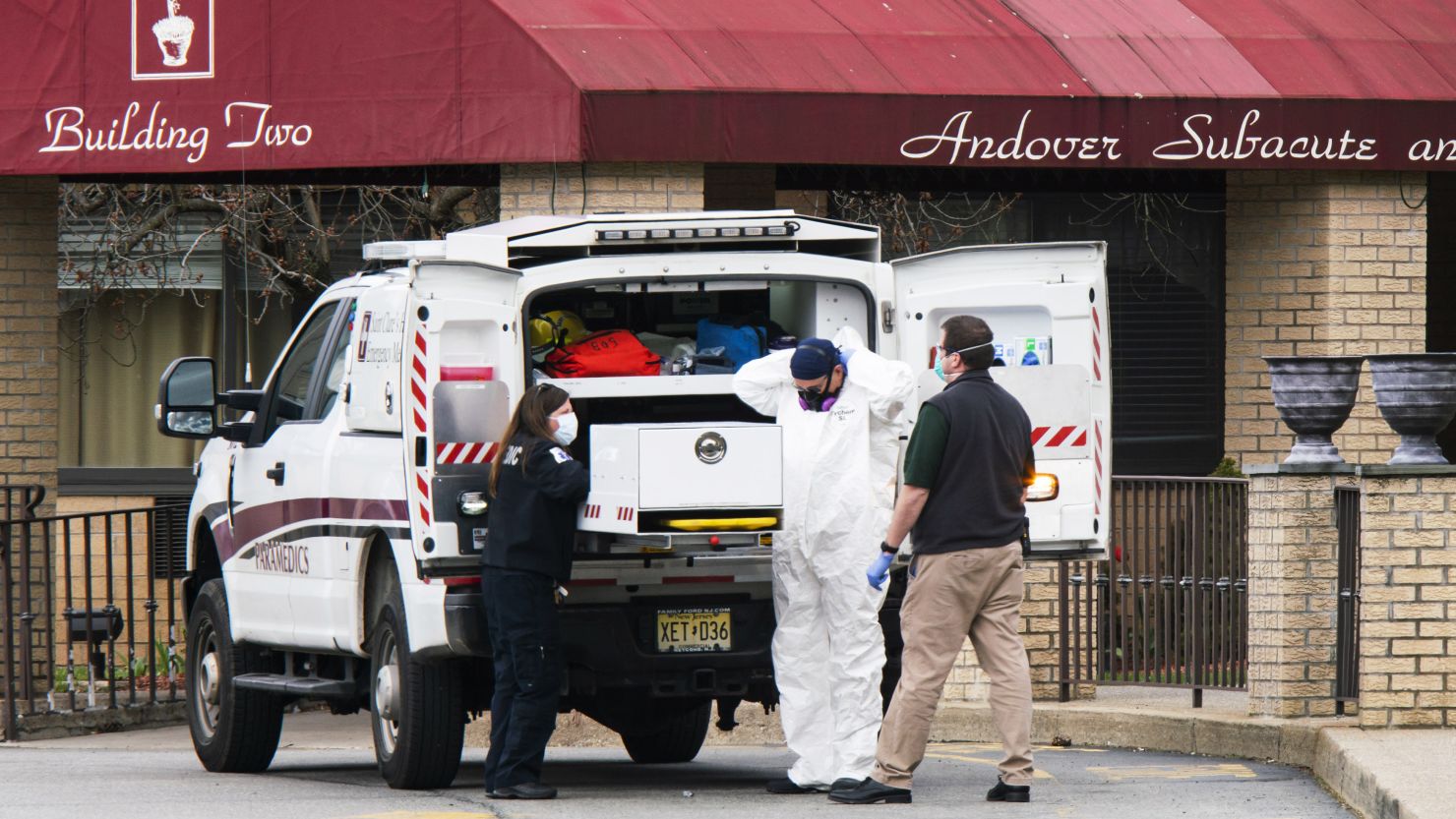 Medical workers put on masks and personal protective equipment while preparing to transport a body at Andover Subacute and Rehabilitation Center on Thursday in Andover, New Jersey.