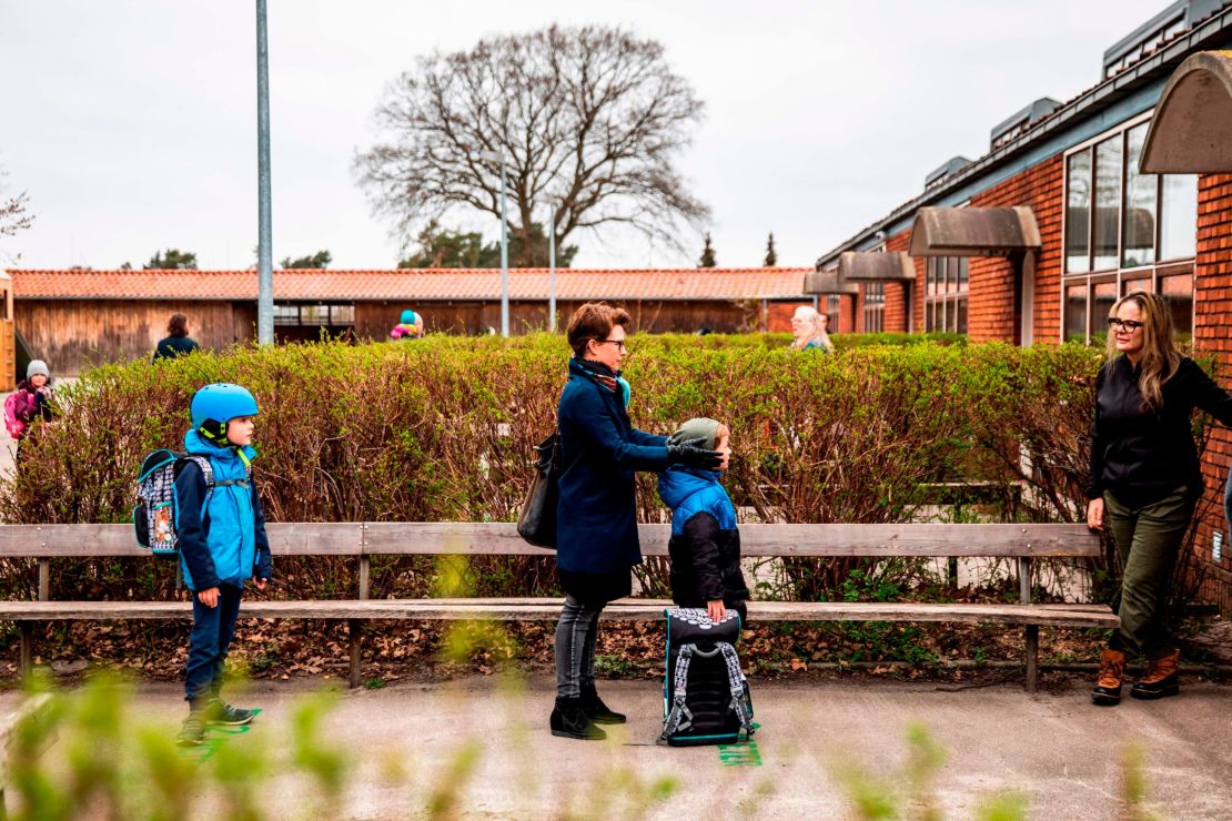 Parents stand with their children as they wait to enter Stengaard School north of Copenhagen, Denmark, on April 15.