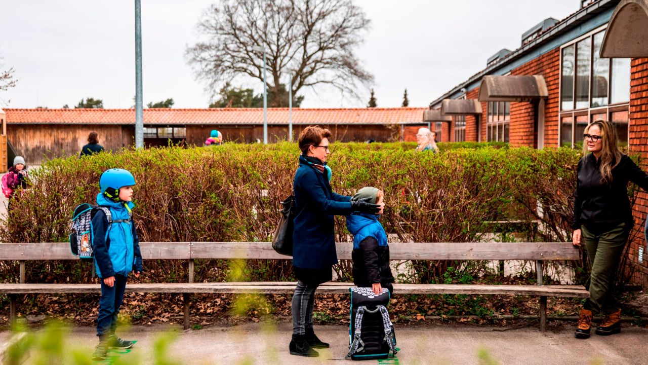 Parents stand with their children as they wait to enter Stengaard School north of Copenhagen, Denmark, on April 15.