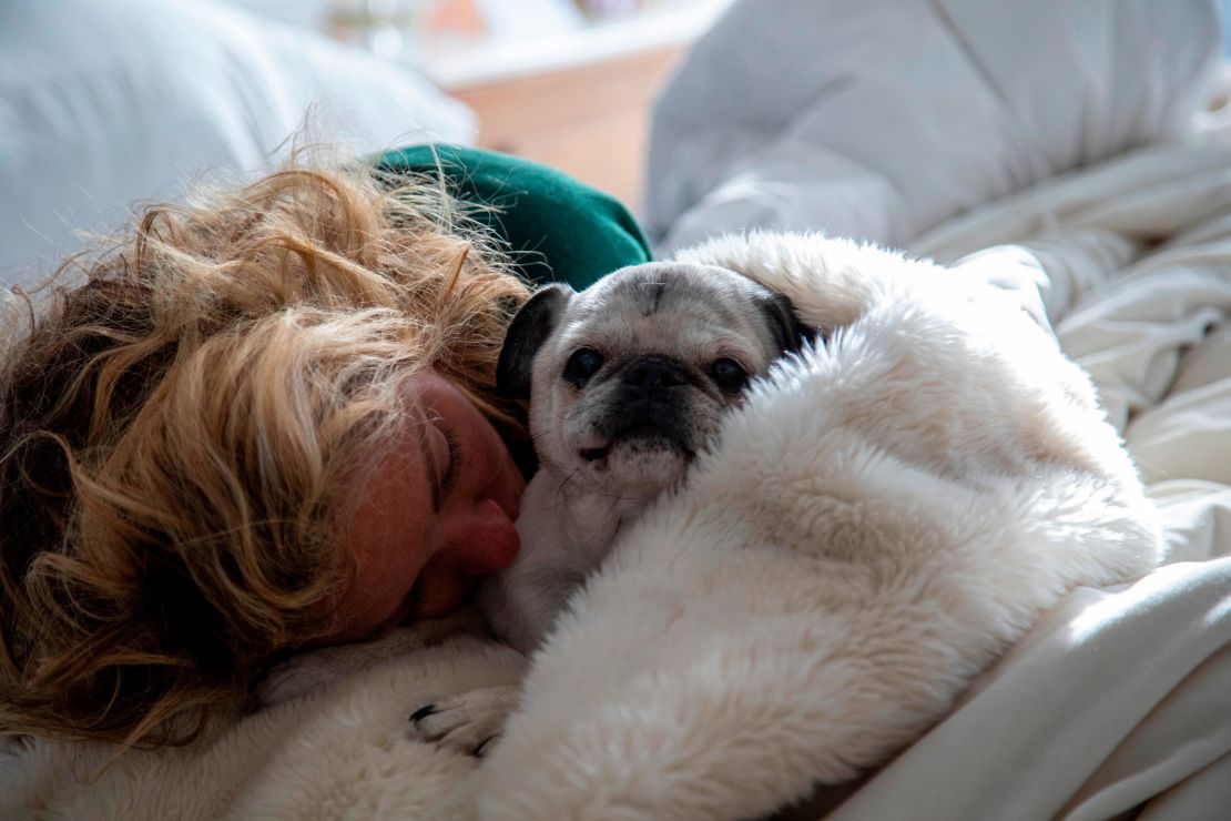 Laid very low by the coronavirus, Baldwin naps with her dog Pugsley.