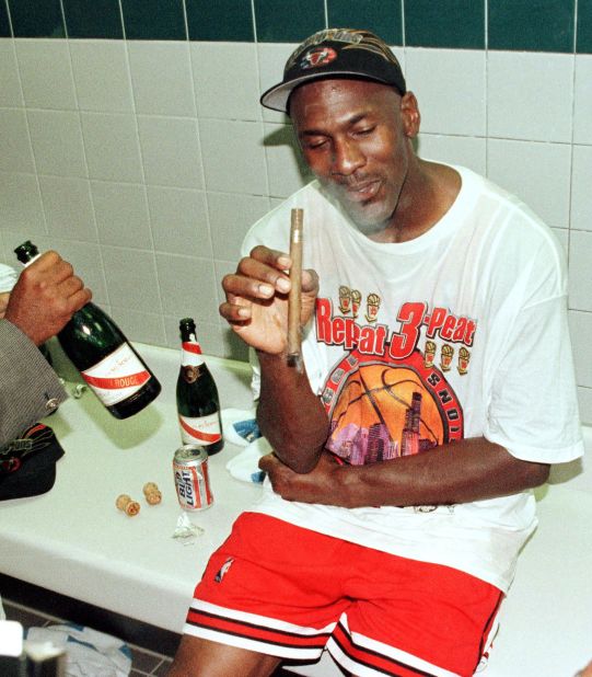 Jordan enjoys a cigar in the locker room after the Bulls finished off their second "three-peat" of the decade.