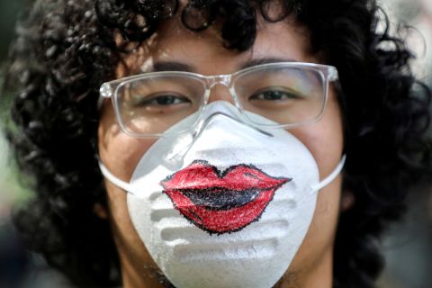 A man in Kuala Lumpur, Malaysia, wears a protective mask featuring a pair of lips.