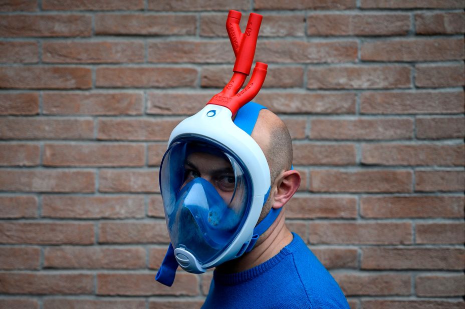 Engineer Mario Milanesio poses with a snorkeling mask that he added respiratory valve fittings to in Savigliano, Italy. He designed and produced them with a 3-D printer.