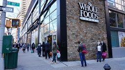 People are seen lined up in front of Whole Foods during the coronavirus pandemic on April 15, 2020 in New York City. Grocery stores across the country have limited the number of customers allowed inside. (Photo by Cindy Ord/Getty Images)
