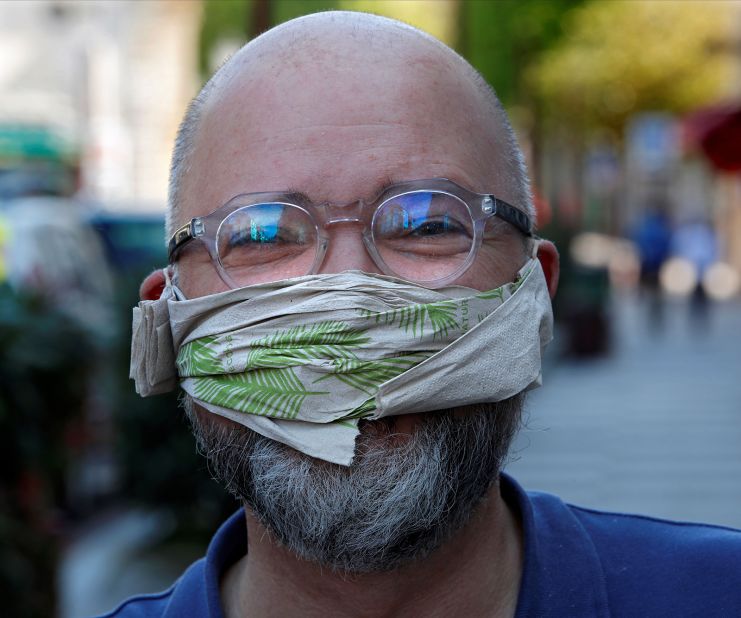 A man in Sceaux, France, poses with a mask made out of a paper napkin.