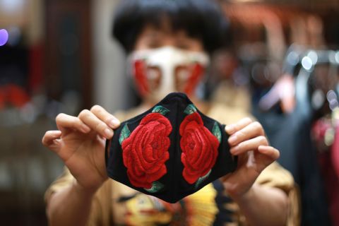 Fashion designer Do Quyen Hoa shows off an embroidered face mask at her studio in Hanoi, Vietnam.