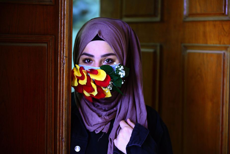 A woman in Najaf, Iraq, wears a mask embellished with flower petals.