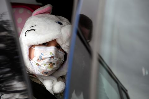 A girl wearing a protective mask leaves a hospital in Oviedo, Spain.