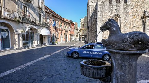 A police car patrols an empty street in Taormina this month after restrictions were imposed to avoid the spread of Covid-19.