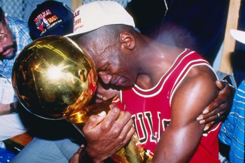 An emotional Jordan embraces the Larry O'Brien Championship Trophy after the Bulls defeated the Lakers to win his first NBA title.