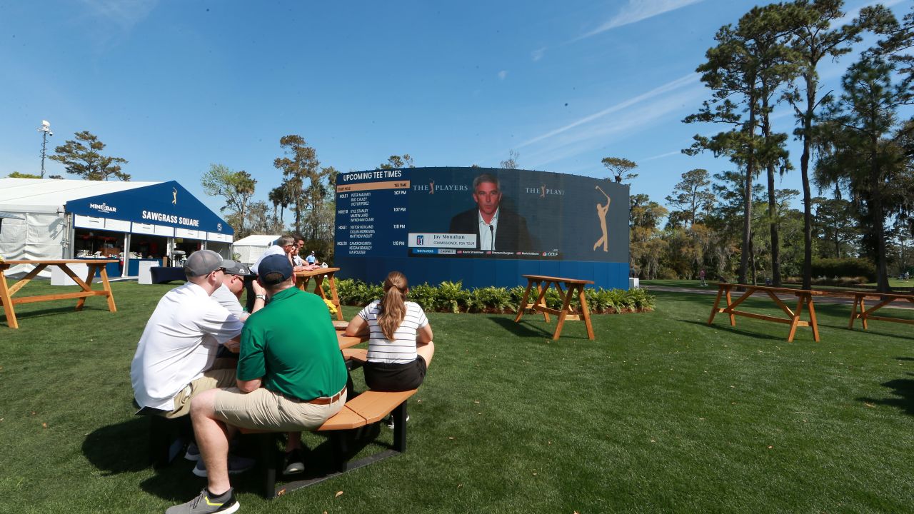 Fans watch on video screens as Monahan speaks to the media in a press conference announcing fans will no longer be allowed to attend PGA tour events.