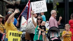 Protesters demanding Florida businesses and government reopen, march in downtown Orlando, Fla., Friday, April 17, 2020. Small-government groups, supporters of President Donald Trump, anti-vaccine advocates, gun rights backers and supporters of right-wing causes have united behind a deep suspicion of efforts to shut down daily life to slow the spread of the coronavirus. (AP Photo/John Raoux)