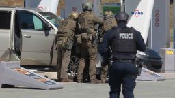 Royal Canadian Mounted Police officers prepare to take a suspect into custody at a gas station in Enfield, Nova Scotia, on Sunday April 19, 2020.