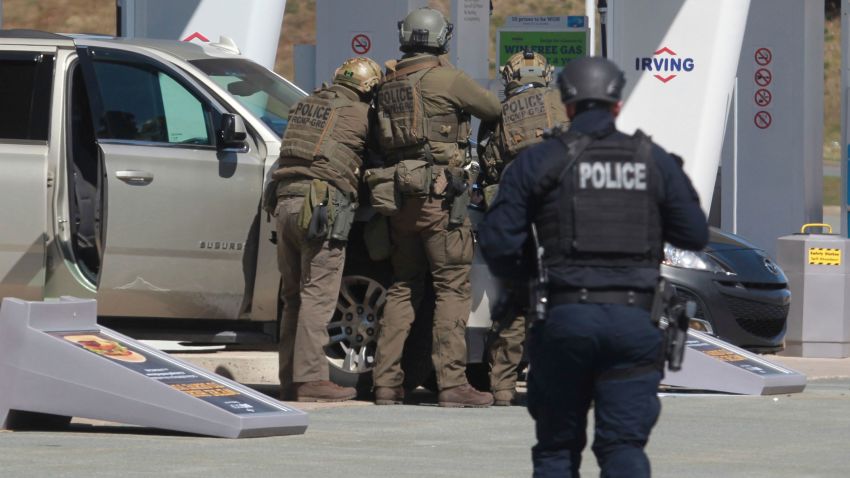 Royal Canadian Mounted Police officers prepare to take a suspect into custody at a gas station in Enfield, Nova Scotia on Sunday April 19, 2020. Canadian police  arrested a suspect in an active shooter investigation after earlier saying he may have been driving a vehicle resembling a police car and wearing a police uniform.  (Tim Krochak/The Canadian Press via AP)