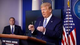 President Donald Trump holds swabs, one that could be used in coronavirus testing, right, as he speaks during a coronavirus task force briefing at the White House, Sunday, April 19, 2020, in Washington.