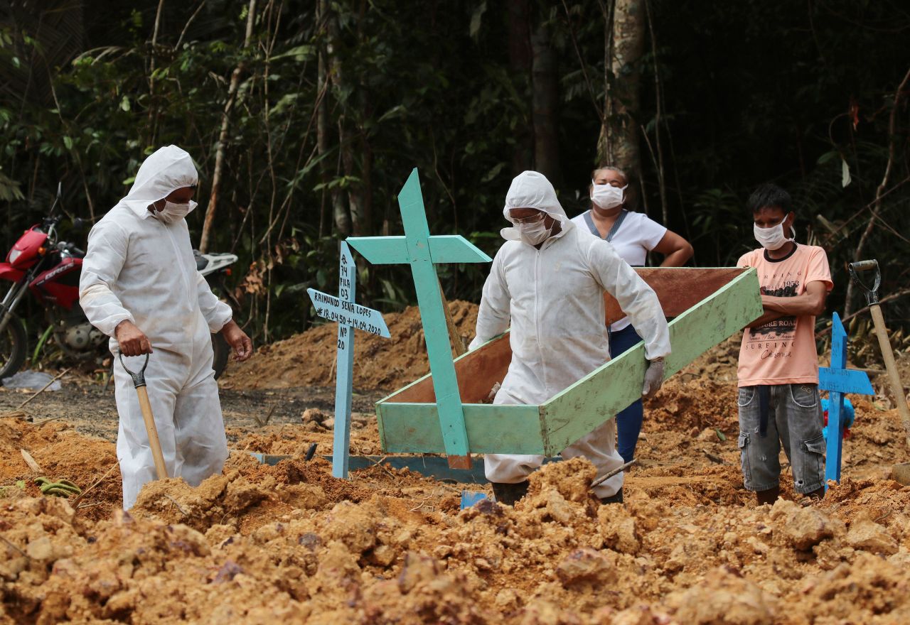 Funeral workers in Manaus, Brazil, prepare the grave of a woman who was suspected to have died from the coronavirus.