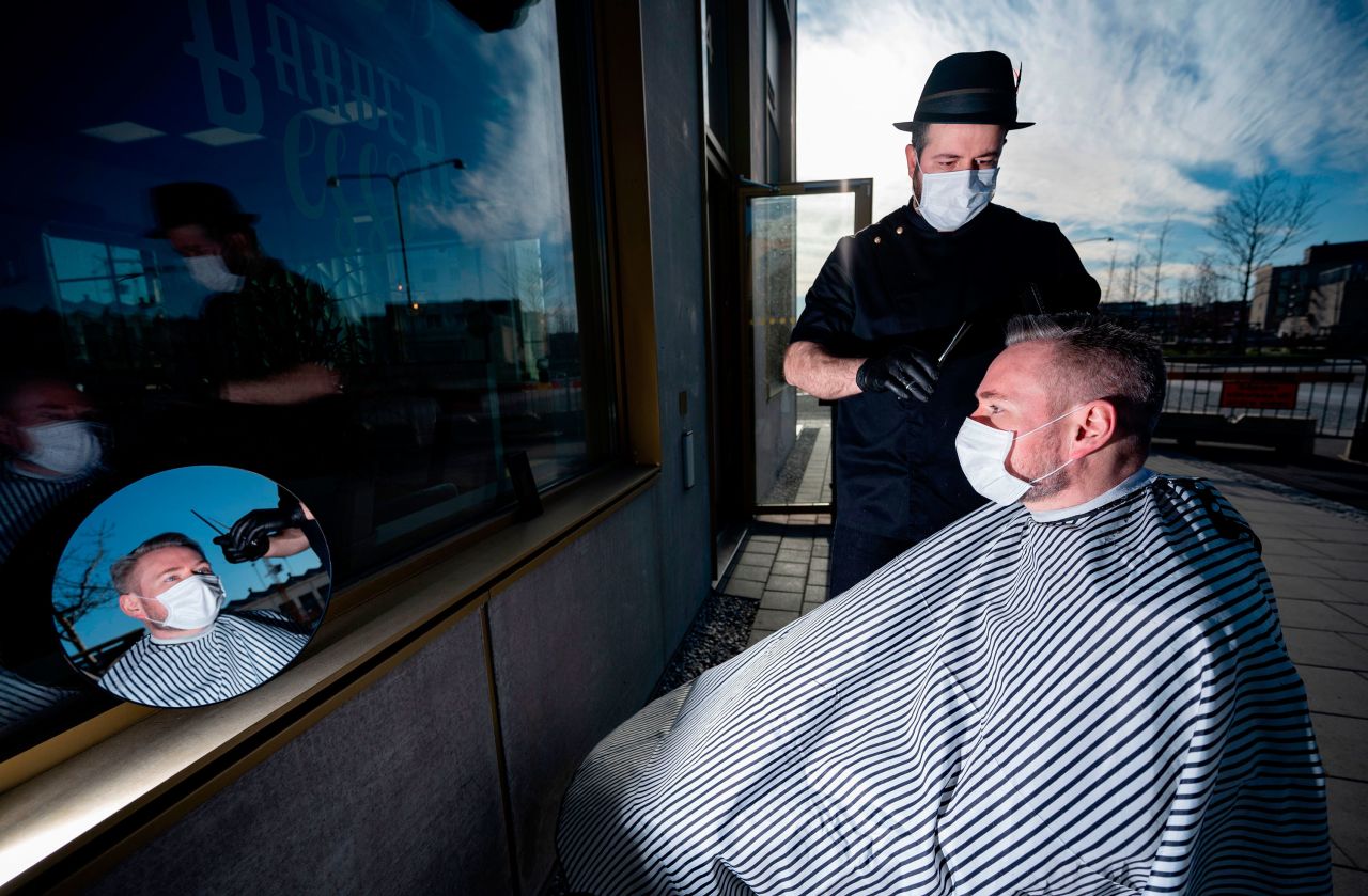 Abed Khankan cuts a customer's hair outdoors in Malmo, Sweden.