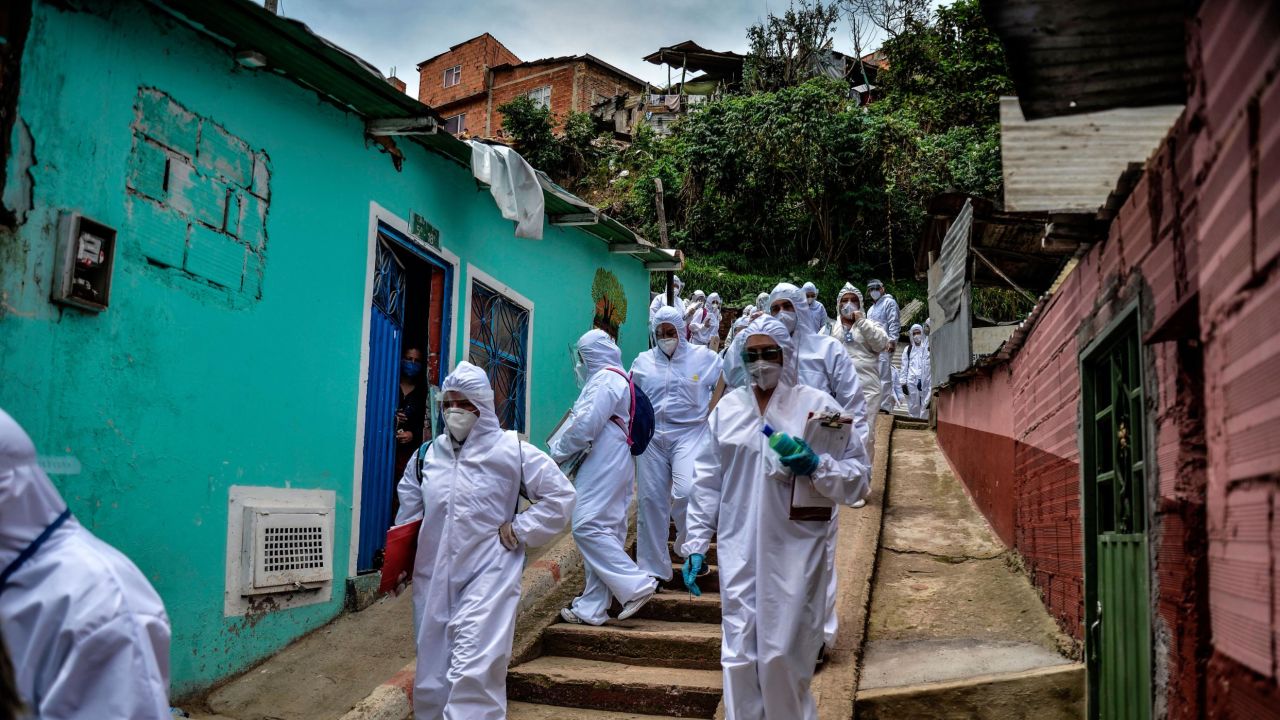Mayor's office workers wear protective suits as they conduct a census in a Bogota, Colombia, neighborhood on April 19, 2020. They were trying to find out how many families needed to be provided with food.