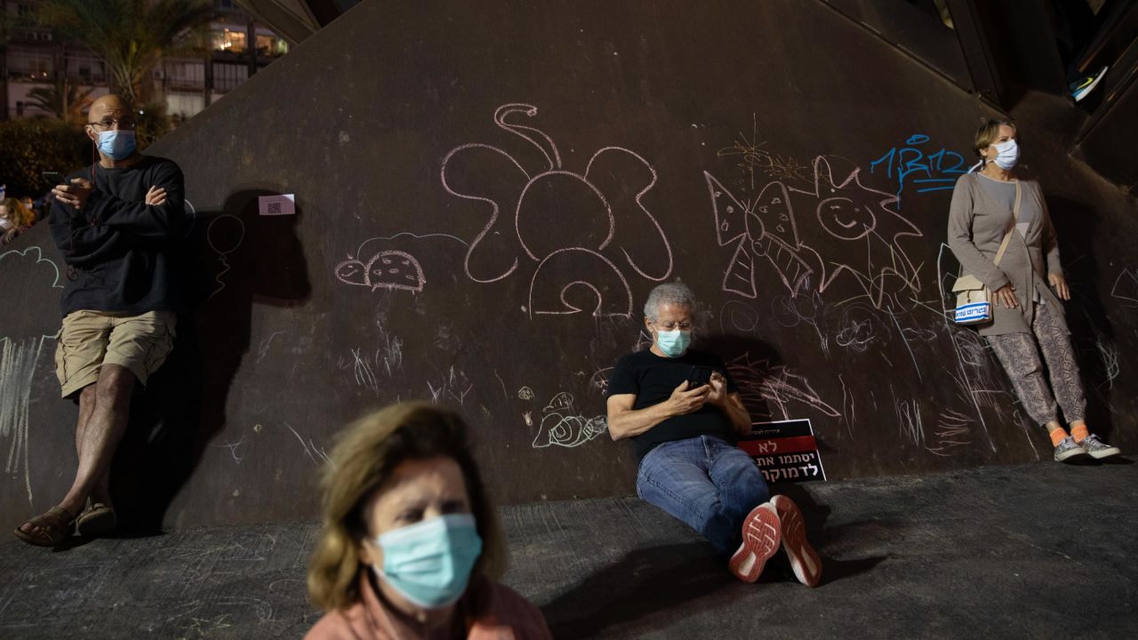 People wearing protective face masks take part in Sunday's protest.