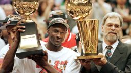 SALT LAKE CITY, UNITED STATES:  Michael Jordan (L) and Chicago Bulls head coach Phil Jackson (R) Most Valuable Player trophy (L) and the Larry O'Brian trophy (R) 14 June after winning game six of the NBA Finals with the Utah Jazz at the Delta Center in Salt Lake City, UT. The Bulls won the game 87-86 to take their sixth NBA championship.   AFP PHOTO Jeff HAYNES (Photo credit should read JEFF HAYNES/AFP via Getty Images)
