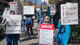 Nurses hold signs during a demonstration for increased personal protection equipment outside Montefiore Hospital in the Bronx borough of New York, U.S., on Thursday, April 2, 2020. Health-care workers and others essential to the Covid-19 fight say they're increasingly frustrated that they're being sent into a deadly battle without the protective gear they need for themselves and their patients. Photographer: David Dee Delgado/Bloomberg via Getty Images