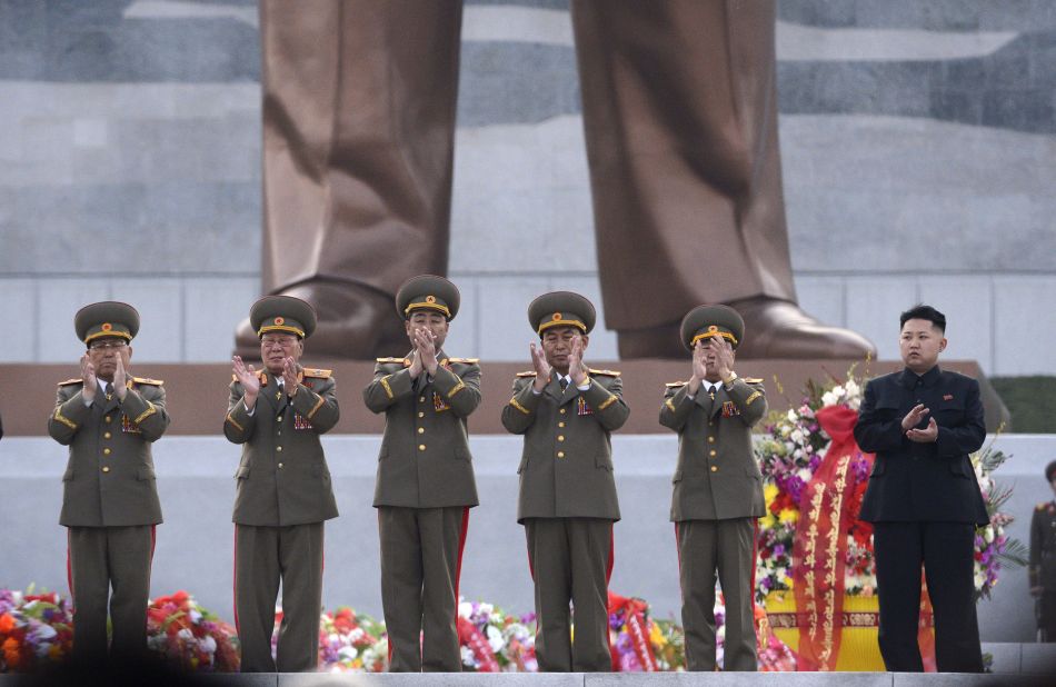 Kim claps as statues of his father and grandfather are unveiled in Pyongyang in April 2012.