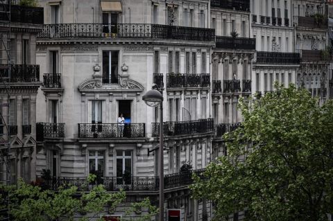 A woman applauds from the balcony of her Paris home to show support for health care workers on April 20, 2020.