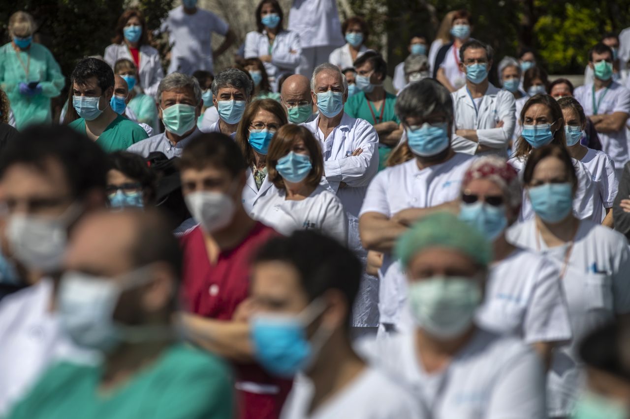 Health workers at Madrid's La Paz Hospital hold a minute of silence to remember Joaquin Diaz, the hospital's chief of surgery who died because of the coronavirus.
