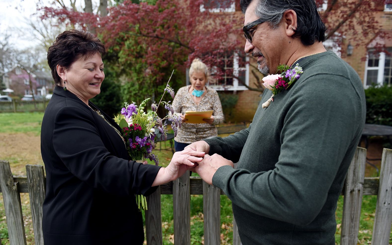 A newly married couple exchange wedding rings in front of the home of a Virginia state marriage officiant in Arlington, Virginia, on April 1.