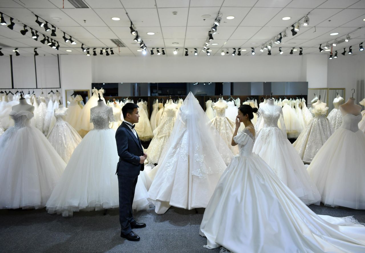 A couple try on a suit and a wedding dress at a wedding service company in Shijiazhuang, China, on April 8.