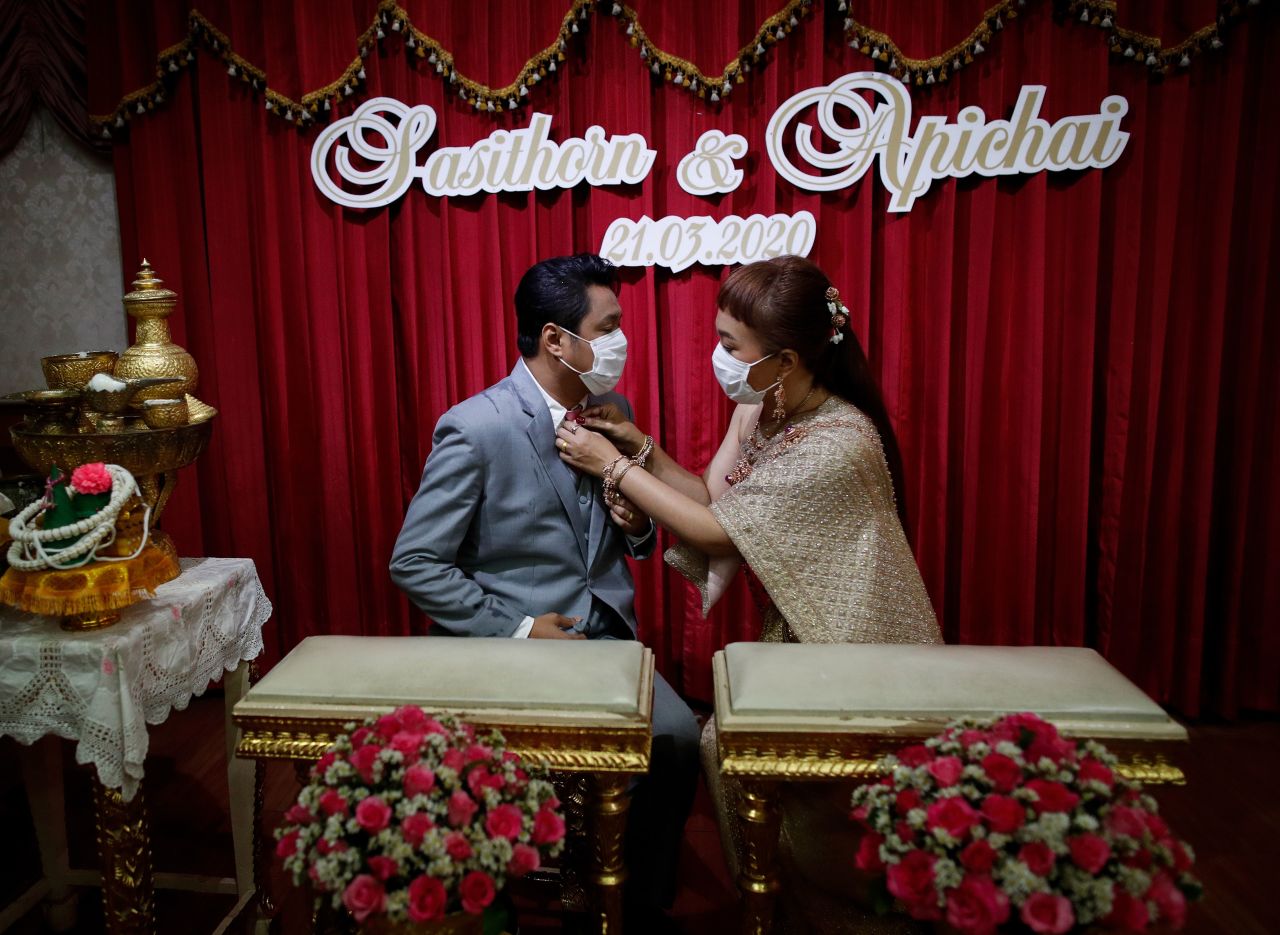 Sasithorn Yunnathai adjusts the necktie of Apichai Chuasawad during a traditional wedding ceremony in Bangkok, Thailand, on March 21.