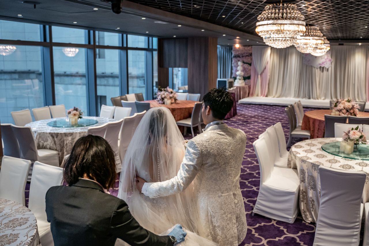 Newlyweds enter an empty room in Hong Kong on March 29. Their wedding banquet was canceled to prevent the spread of the coronavirus.