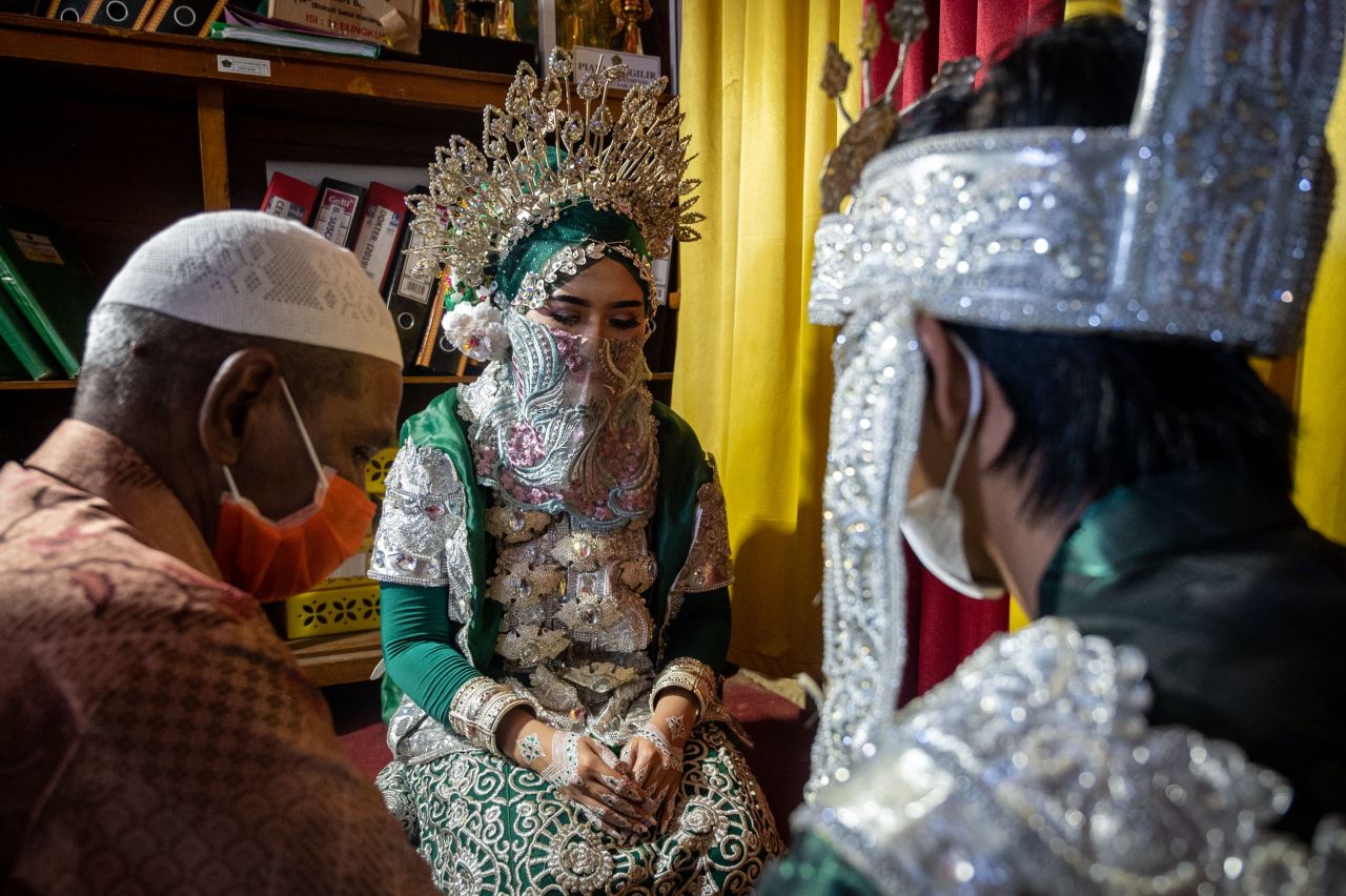 Bride Silviana Dewi, center, and groom Evo Darmawangsah, right, make vows during their wedding ceremony in Siwa, Indonesia, on April 9.