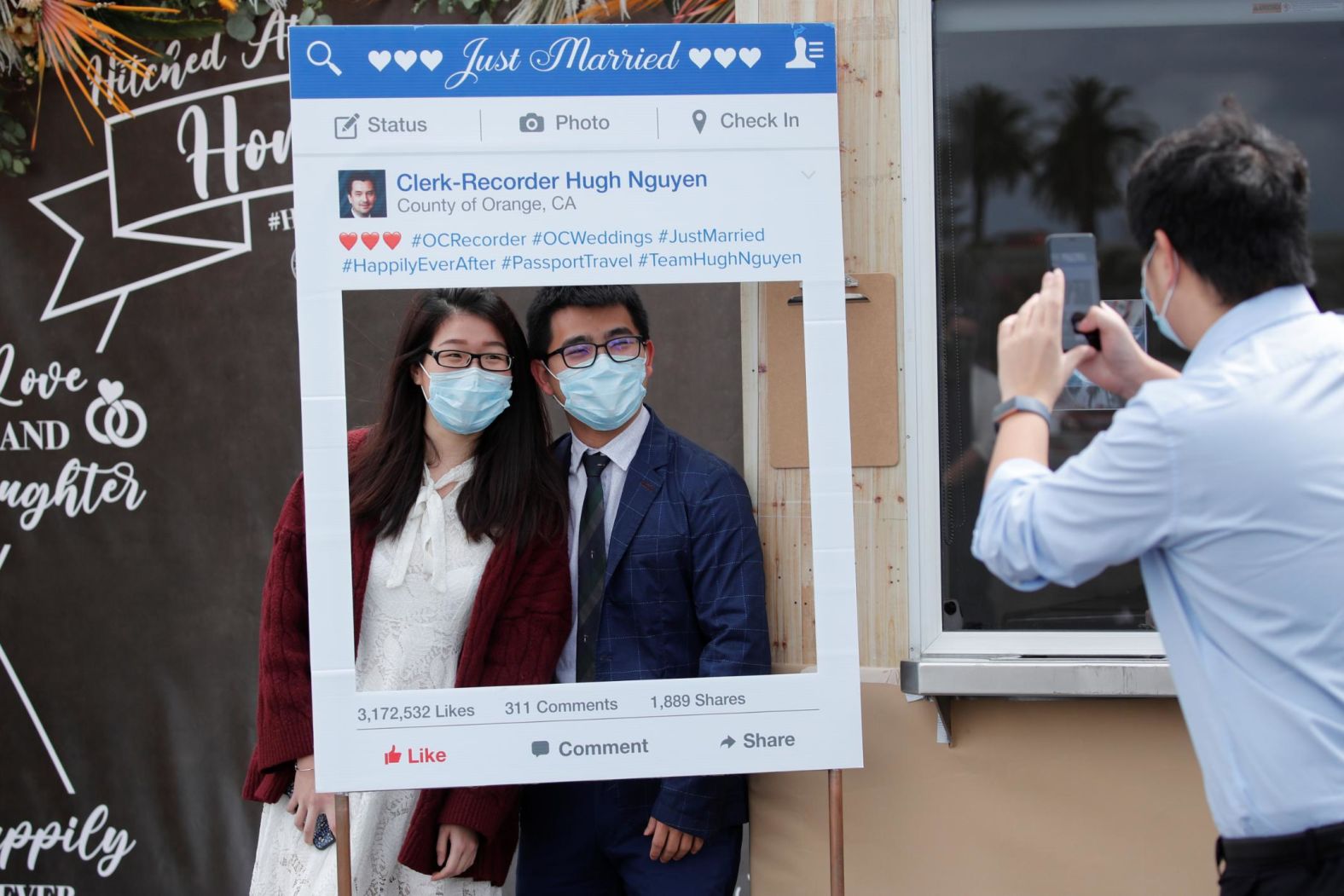 A couple poses for a picture after taking their wedding vows in a parking lot in Anaheim, California, on April 17.