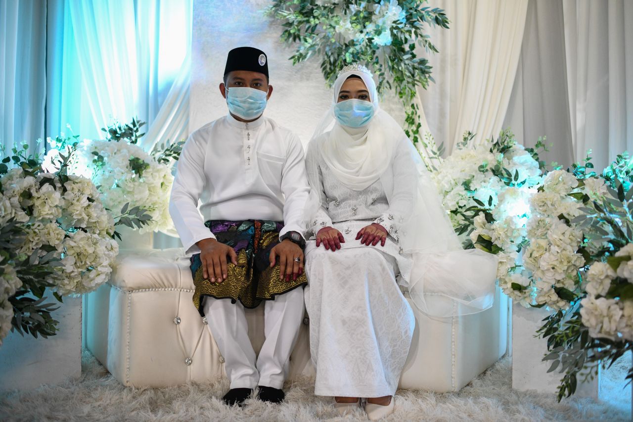 Mohammad Nor Azwan Ishak and Nuramiraalia Noorbashah pose for pictures at a traditional solemnisation ceremony before getting married in a house in Lanchang, Malaysia, on March 20.