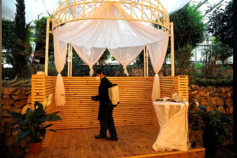 An employee sanitizes the chuppah, or Jewish wedding canopy, before couple Roni Ben-Ari and Yonatan Meushar got married in Ein Hemed, Israel, on March 18.