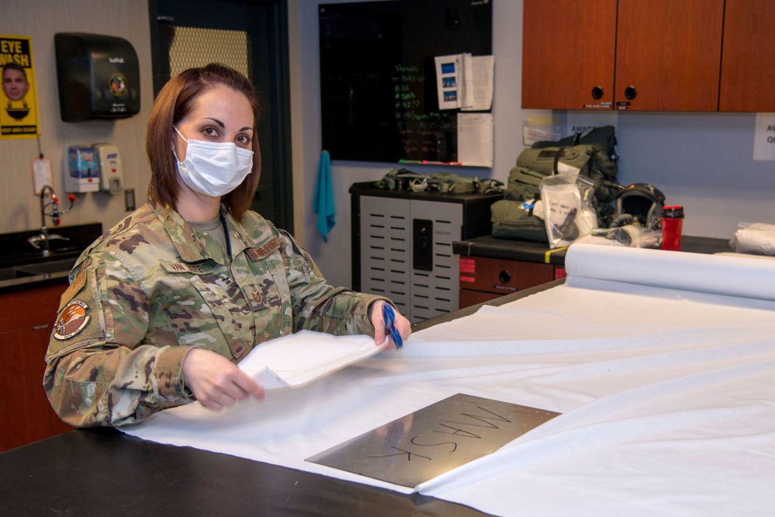 An aircrew flight equipment specialist with the 140th Wing, Colorado National Guard assists with making facemasks.