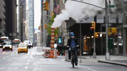 A person wearing a hardhat and face mask rides a bike  on April 21, 2020 in New York City. - Over 2.5 million people have been confirmed to have contracted the coronavirus worldwide, with 80 percent of cases in Europe and the United States, according to an AFP tally Tuesday based on official figures. (Photo by Angela Weiss / AFP) (Photo by ANGELA WEISS/AFP via Getty Images)