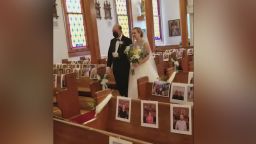 Clare Keefer is walked down the aisle by her father in the church decorated with pictures of the guests, who were not able to attend because of the coronavirus pandemic.