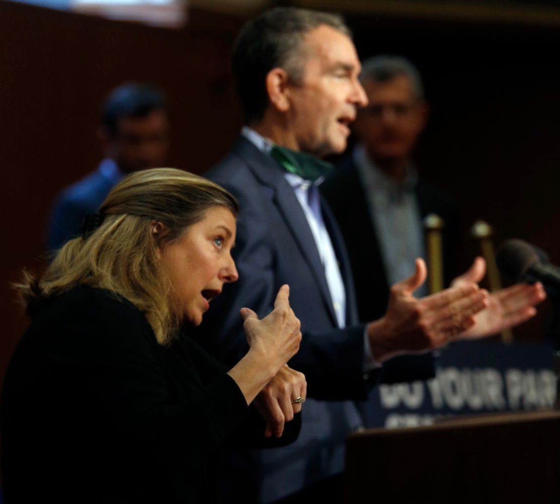 Interpreter Liz Leitch, left, signs as Virginia Governor Ralph Northam gestures while answering a question during his press briefing on April 20, 2020.