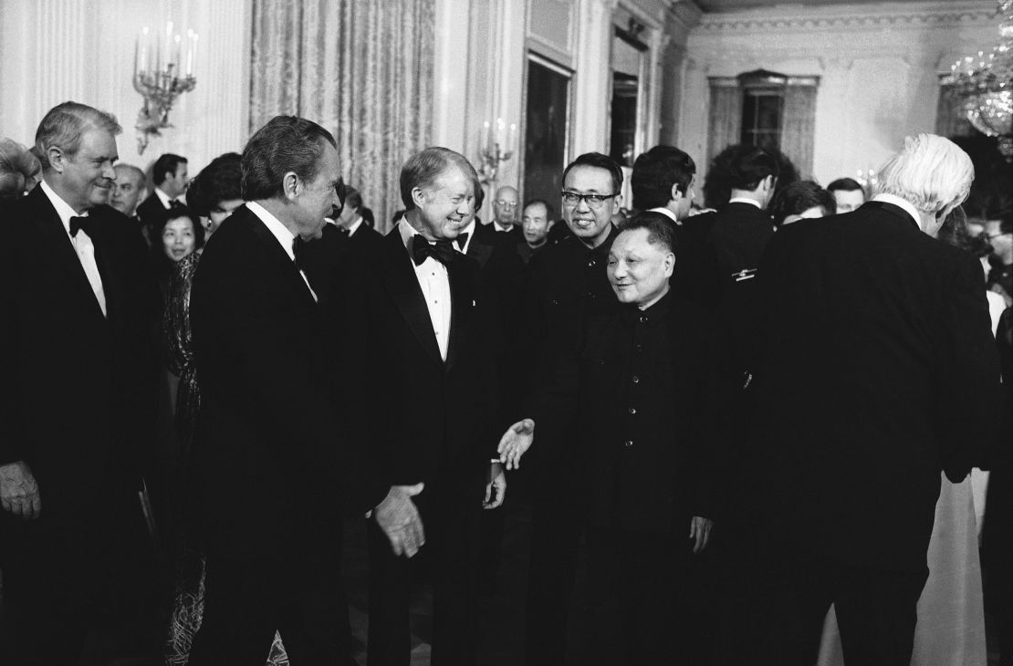 Former President Richard Nixon shakes hands with Chinese Vice Premier Teng Hsiao-ping as President Jimmy Carter stands by.