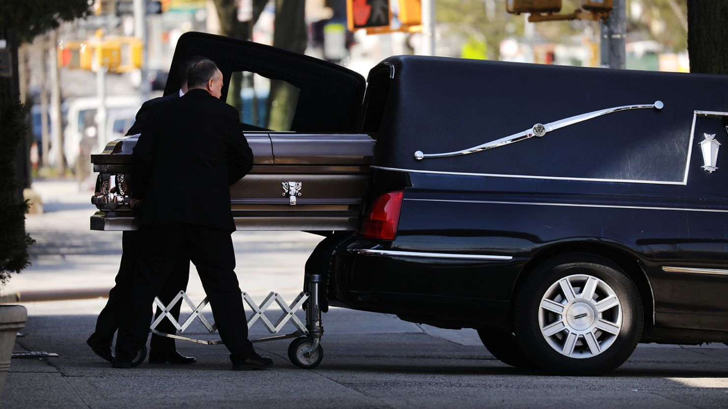 A casket is placed into a hearse outside of a funeral home in Brooklyn. 